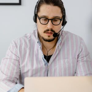 Professional customer support agent working remotely with headset and laptop, focusing on providing excellent service.
